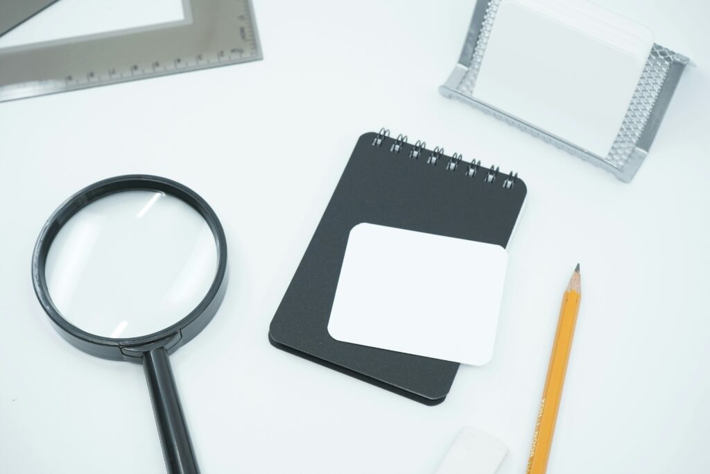 Magnifying glass, notebook and pencil representing the intensive terminology research required for certified legal translation.